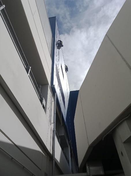 Vista de una fachada moderna donde se realizan trabajos verticales.