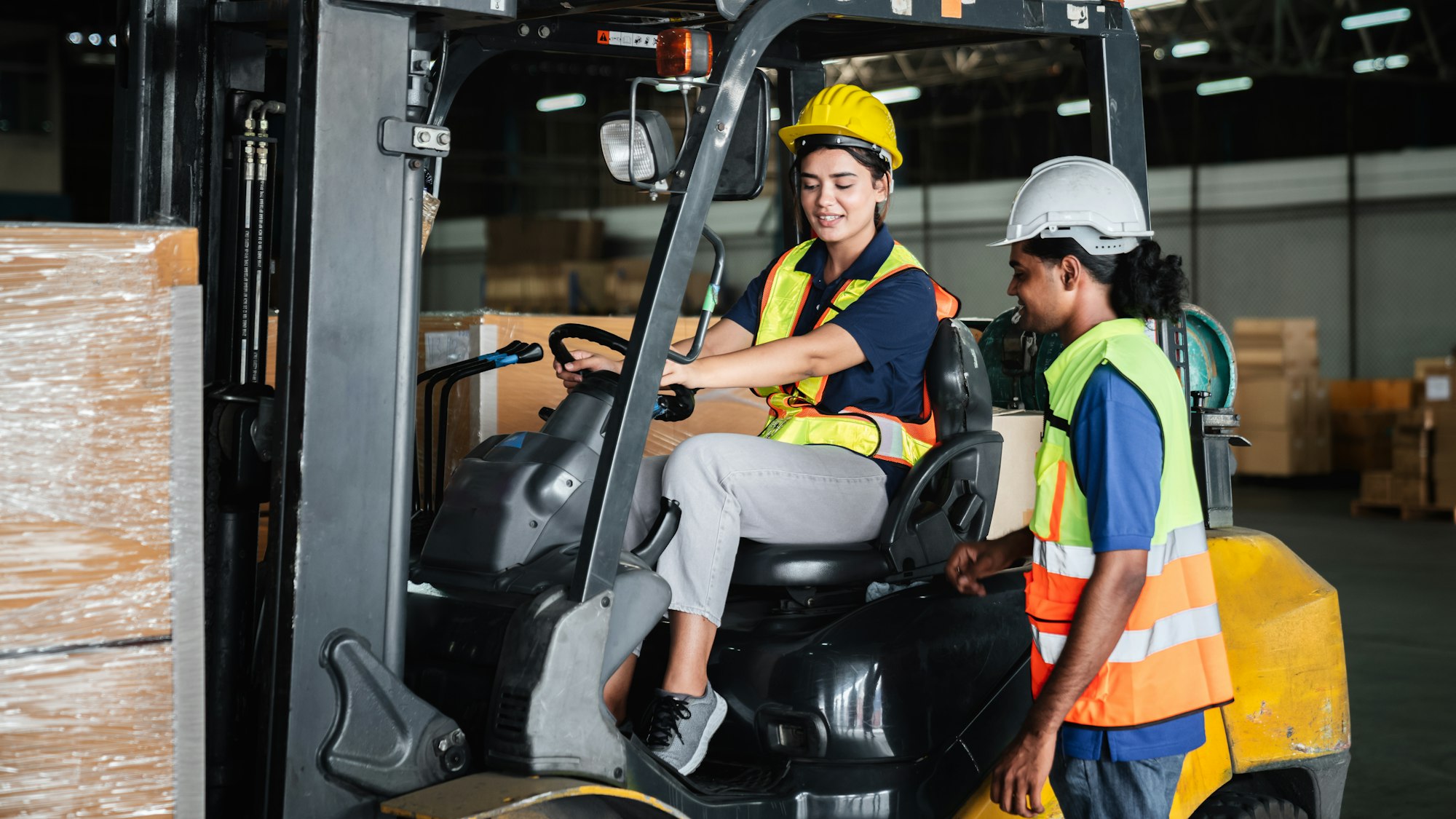 Warehouse worker workers with forklift in a warehouse. Use forklift operator moves packages.