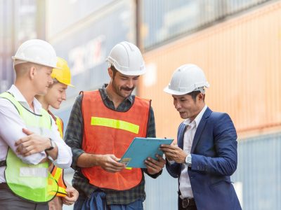 Group of container worker discussing work at a dock