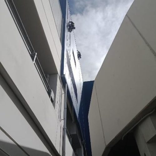 Vista de una fachada moderna donde se realizan trabajos verticales.